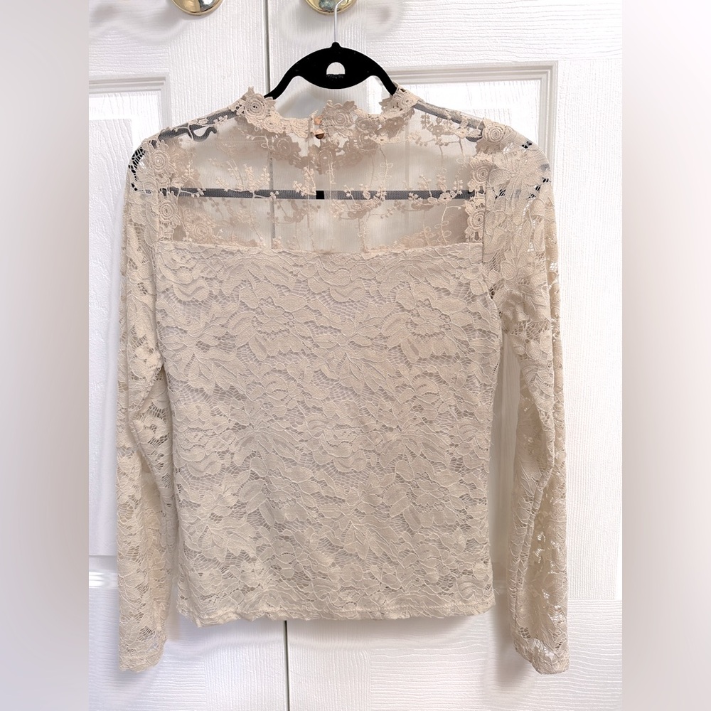 Long sleeve lace top with a round neckline. Size 2 or 4US new condition